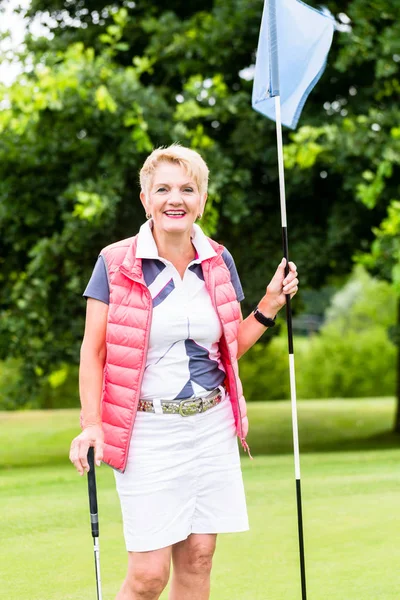 Äldre kvinna som spelar golf — Stockfoto