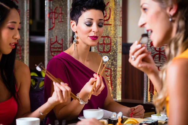 Young people eating sushi Stock Photo