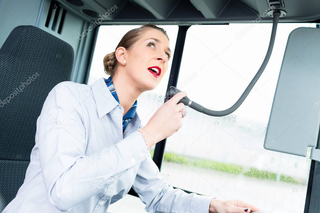 Bus driver woman speaking into the microphone