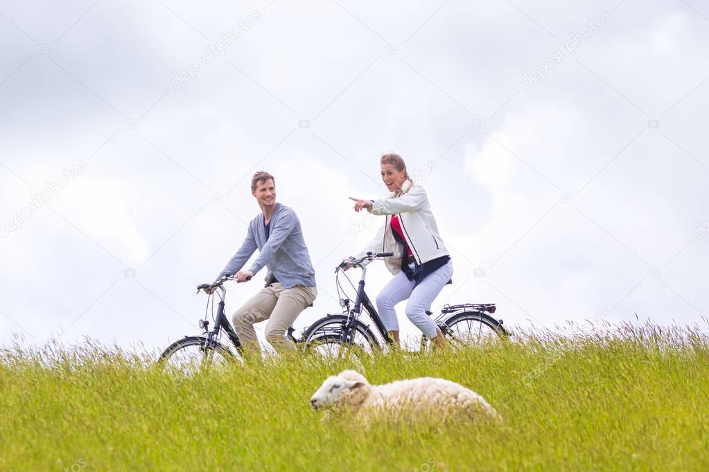 Couple having sea coast bicycle tour at levee