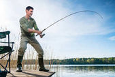 Rybář, chytání ryb rybaření na jezeře