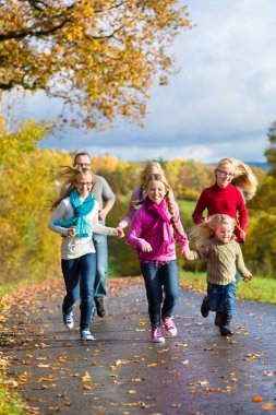 Family take walk in autumn forest clipart