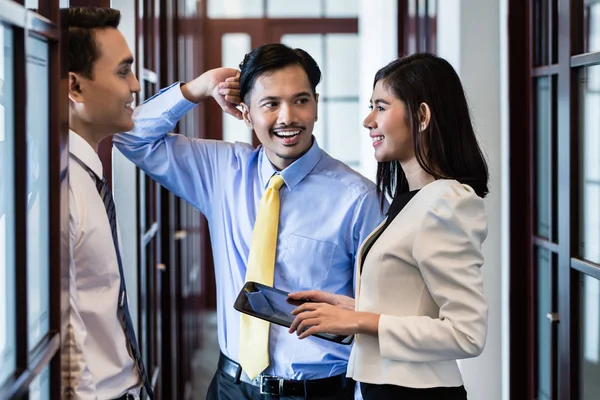 Co-workers in office hallway talk about project — Stock Photo, Image