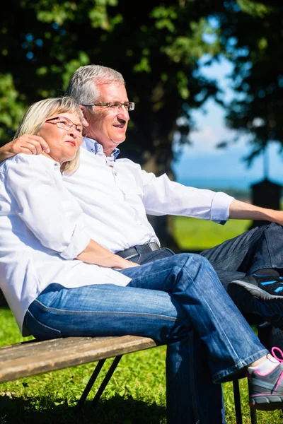 Senior mulher e homem descansando no banco abraçando — Fotografia de Stock