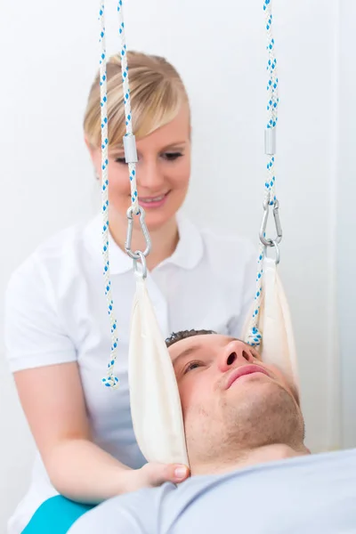 Fisioterapeuta ejercitando al paciente sobre la mesa de cabestrillo — Foto de Stock