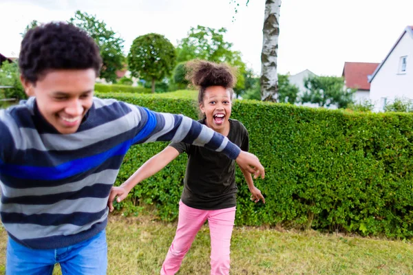 Irmãos brincando no jardim — Fotografia de Stock