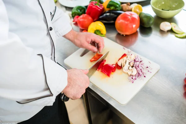 Chef coupant oignons et légumes — Photo