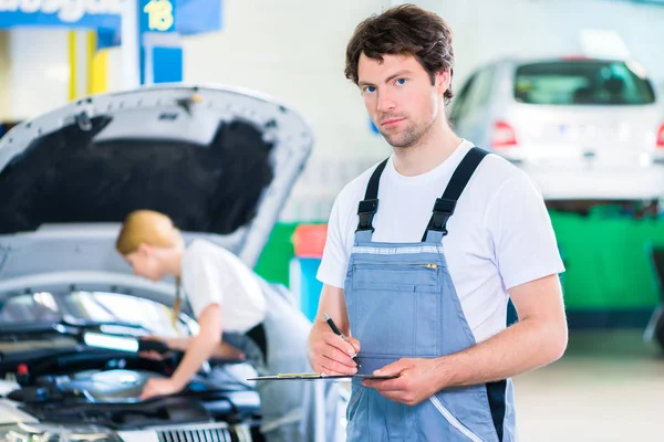 Carro mecânico equipe de trabalho em oficina de automóveis — Fotografia de Stock