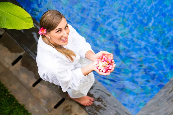 Donna con fiori a bordo piscina tropicale — Foto Stock