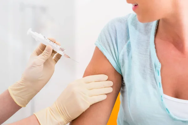 Женщина у врача получает шприц для вакцинации — стоковое фото