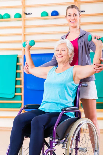 Seniorin im Rollstuhl macht Physiotherapie — Stockfoto