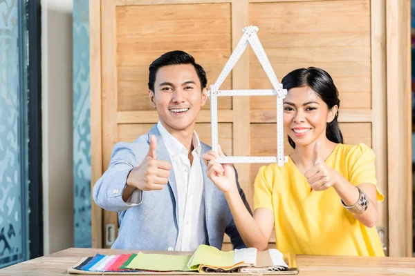 Asiatisches Paar mit Zollstock im Möbelhaus — Stockfoto