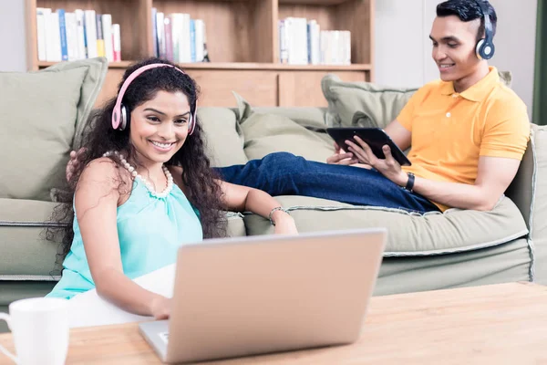 Pareja india en su sala de estar con computadora —  Fotos de Stock