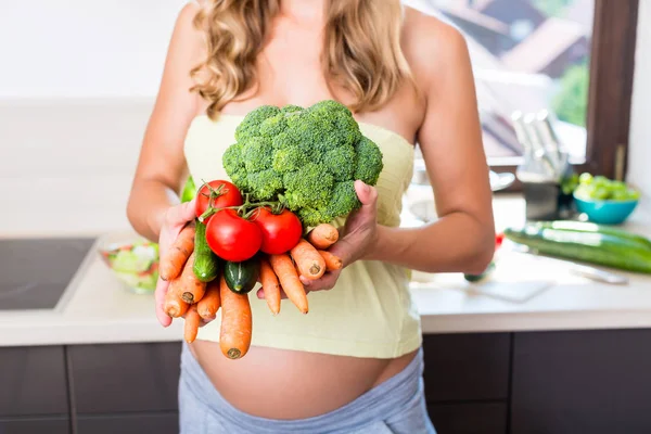 Женщина во время беременности ест здоровые овощи — стоковое фото