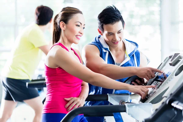 Coach evaluar el rendimiento de la mujer en la cinta de correr — Foto de Stock