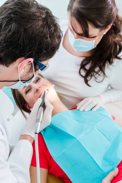 Dentist and nurse treating woman — Stock Photo, Image