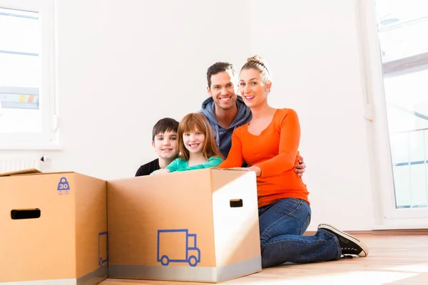 Family unpacking moving boxes — Stock Photo, Image
