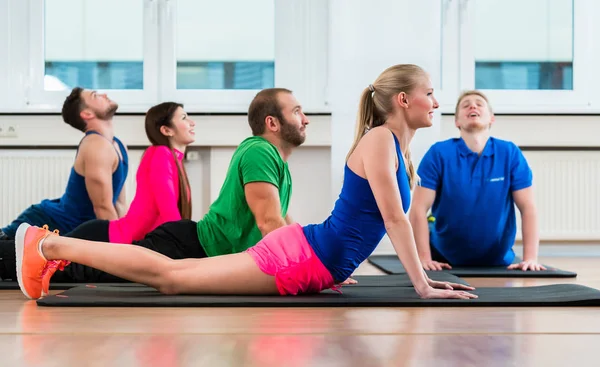 Recreatieve atleten doen yoga oefeningen in fitness gym — Stockfoto