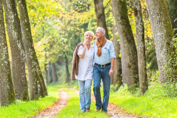 Pareja mayor teniendo ocio caminar en el bosque — Foto de Stock