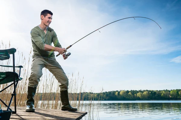 Pêcheur attrapant des poissons pêchant au lac — Photo