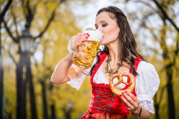 Meisje in traditionele Beierse klederdracht drinken bier uit enorme mu — Stockfoto