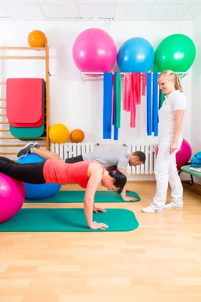 Fysiotherapeut geven patiënten gymnastische oefening — Stockfoto