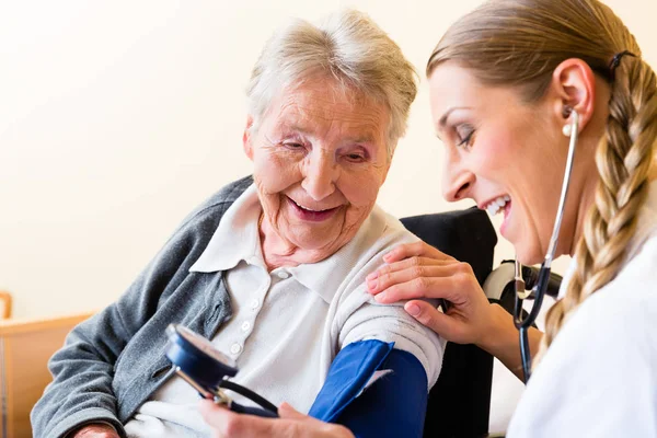 Krankenschwester misst Blutdruck bei Seniorin — Stockfoto