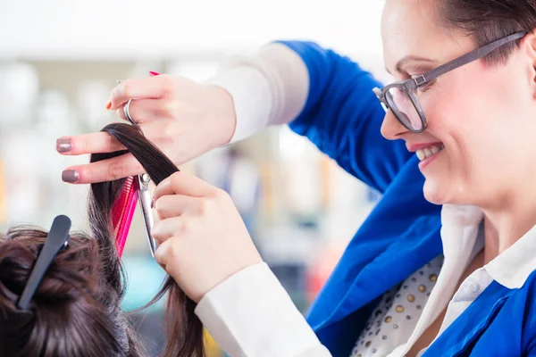 Friseur stylt Damenhaare im Geschäft — Stockfoto