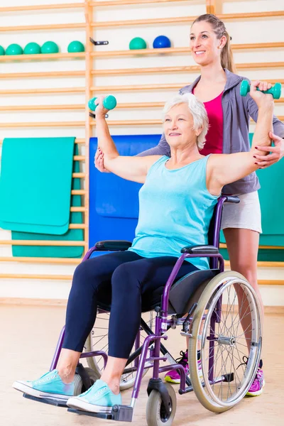 Seniorin im Rollstuhl macht Physiotherapie — Stockfoto