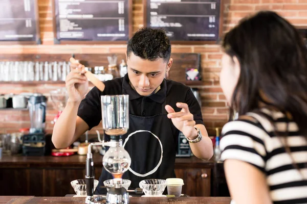 Vrouw kijken naar barista koffie bereiden — Stockfoto