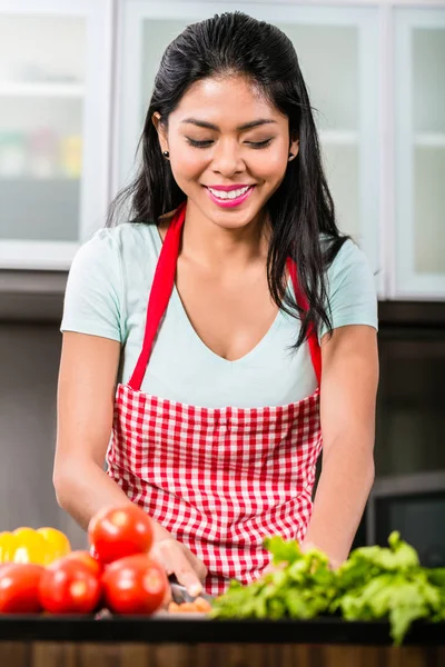 Mulher asiática cortando legumes e salada — Fotografia de Stock