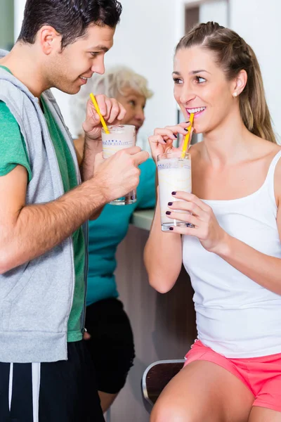 Люди пьют протеиновые коктейли в фитнес-зале — стоковое фото