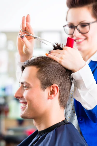 Coiffeur coupe les cheveux de l'homme dans le salon de coiffure — Photo