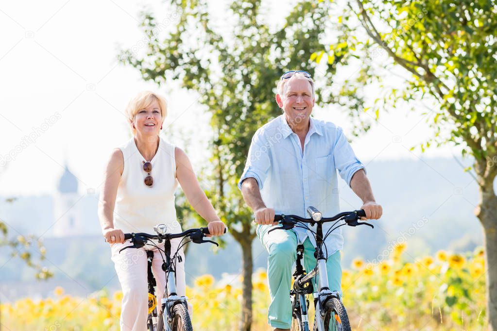 Senior couple, woman and man, riding their bikes