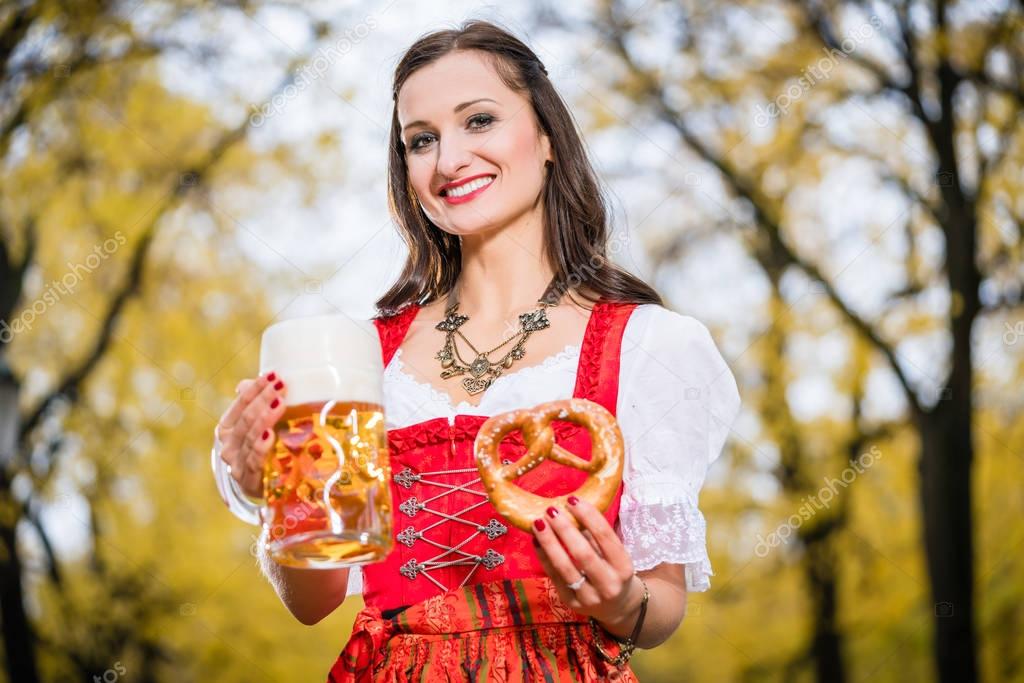 Girl wearing Dirndl with Pretzel and beer mug