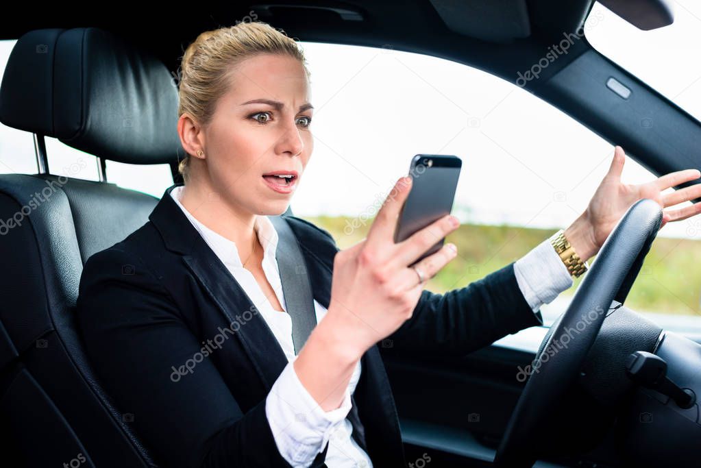 woman texting while driving by car