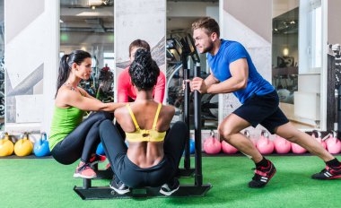 Man pushing women on cart as fitness exercise clipart