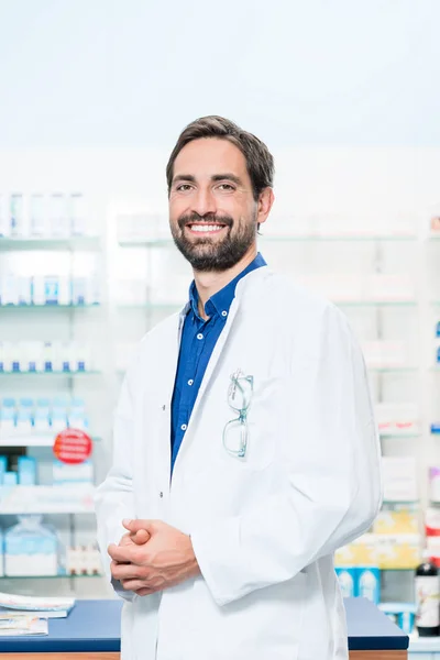 Φαρμακοποιού στο φαρμακείο στέκεται στο ράφι — Φωτογραφία Αρχείου