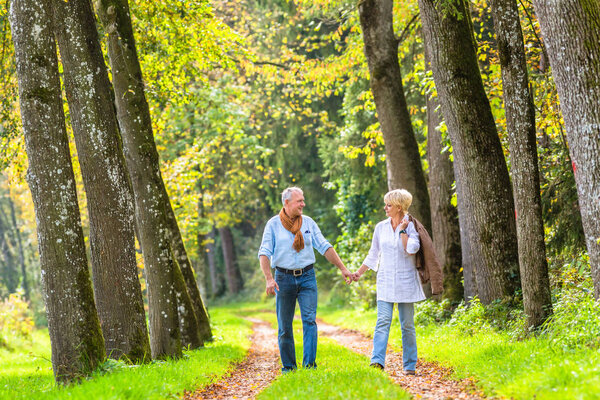 Senior couple having leisure walk in woods