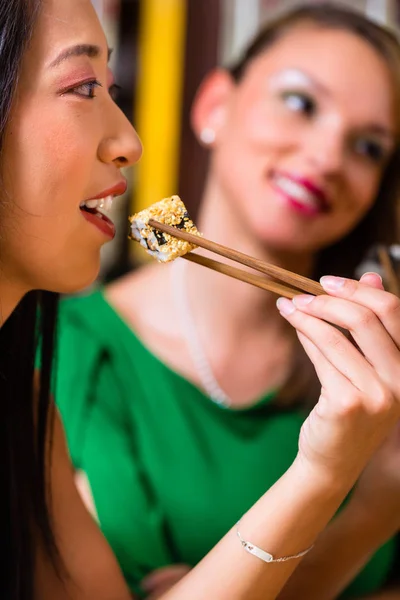 Mladí lidé jíst sushi — Stock fotografie