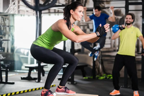 Grupo de hombres y mujeres en el gimnasio de entrenamiento funcional — Foto de Stock