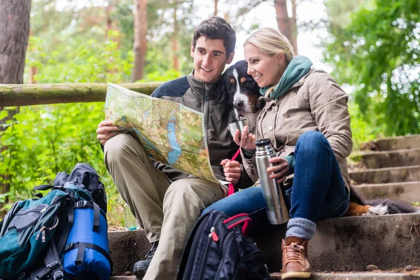 Man and woman on hike planning next route section on map — Stock Photo, Image