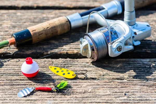 Fishing rod, lure, and hook on jetty — Stock Photo, Image