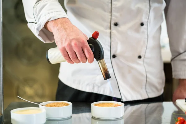 Patissier ou chef brulee creme queimando fazendo sobremesa — Fotografia de Stock