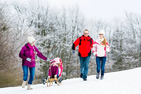 Rodzina z dziećmi mająca zimowy spacer w śniegu — Zdjęcie stockowe