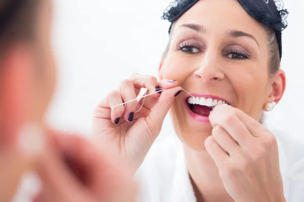 Женщина чистит зубы зубной нитью — стоковое фото