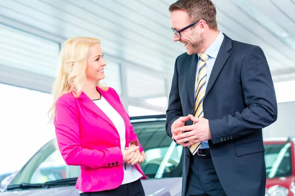 Mujer comprando coche nuevo en concesionario — Foto de Stock