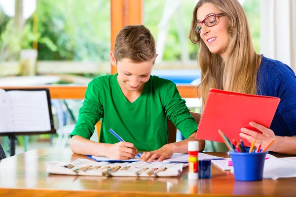 Madre ayudando al hijo con la tarea asignada — Foto de Stock