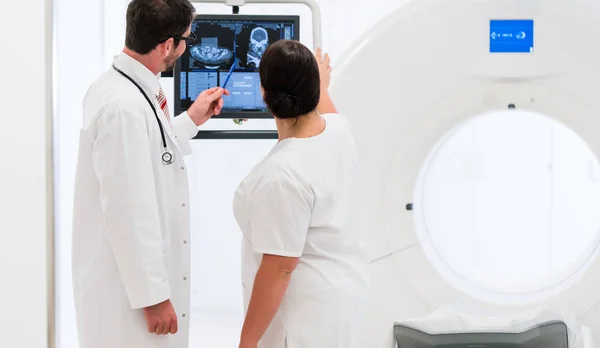 Médico y enfermera analizando datos de tomografía computarizada — Foto de Stock