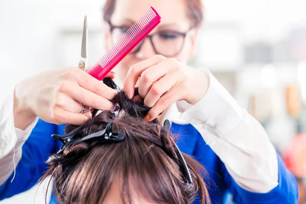 Парикмахер укладки женские волосы в магазине — стоковое фото